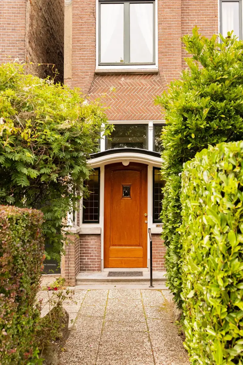 Klassieke voordeur in een vooroorlogse bakstenen gevel